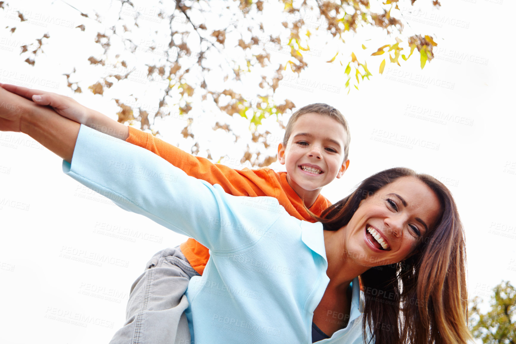 Buy stock photo Mother, boy and outdoor with flying on piggyback for fun on portrait with bonding, support and care. Low angle, parent and happy or smile with kid for child development, growth and childhood memories