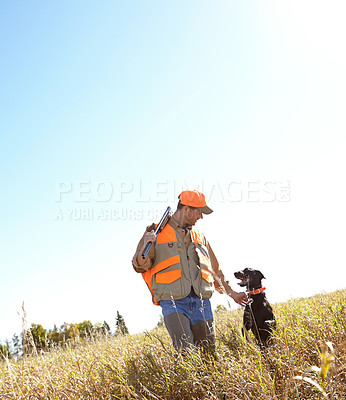 Buy stock photo A hunter holding his shotgun while standing outdoors with his hunting dog