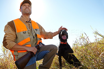 Buy stock photo A hunter petting his retriever dog while crouched alongside him