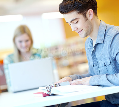 Buy stock photo Education, book and man in library for reading, learning and studying at table. Male student, textbook and information in college for exam preparation, understanding or research subject for knowledge