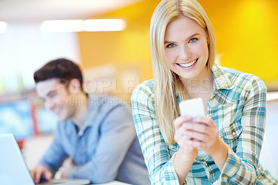 Buy stock photo Education, phone and portrait with student woman in library on campus of college or university for development. App, smile and social media with happy person at desk or table for research or typing