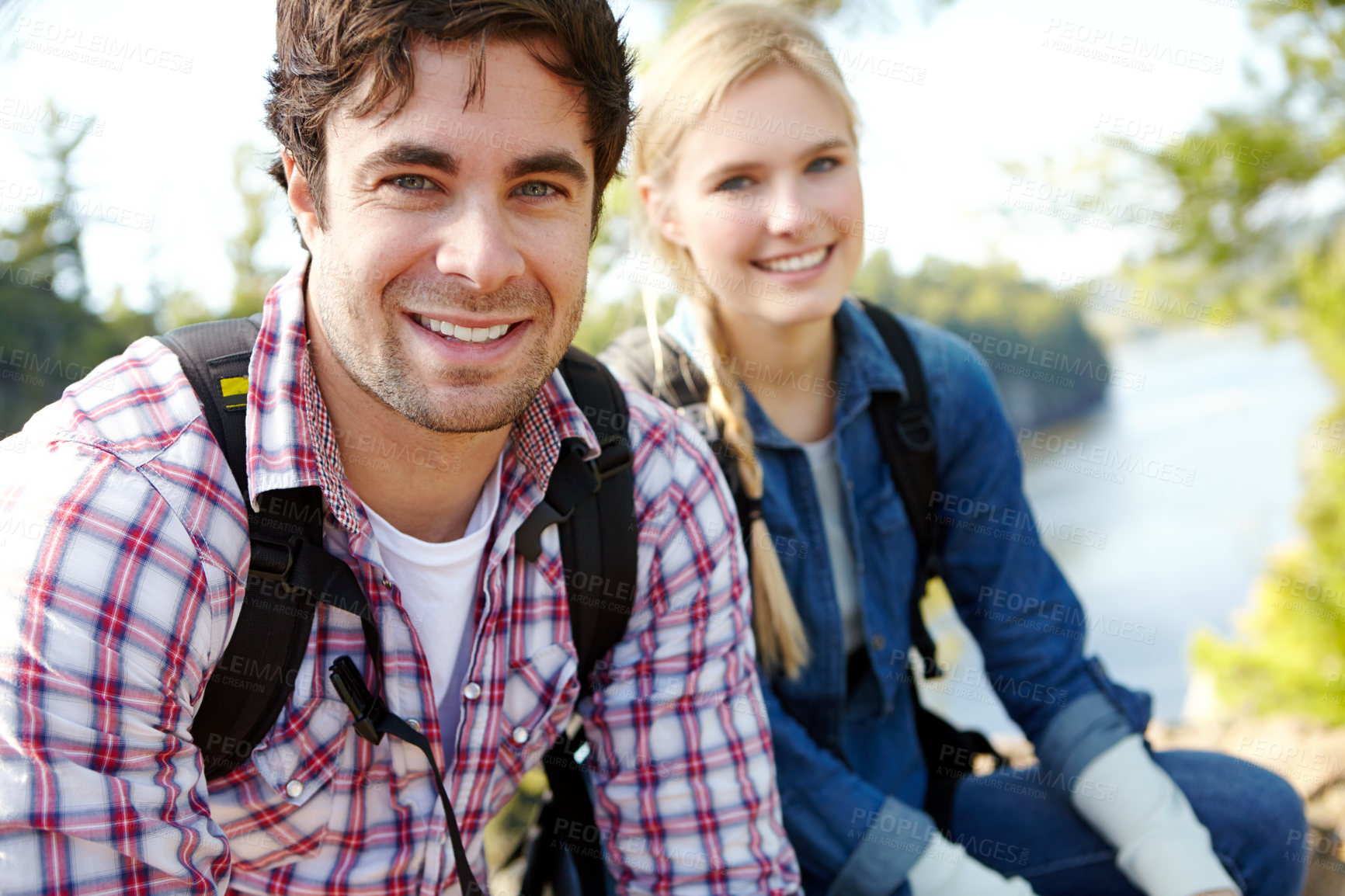 Buy stock photo Break, portrait or happy couple hiking by river for travel, outdoor adventure or journey in nature with smile. Hikers, resting or people in forest on holiday vacation, trip or lake to explore park