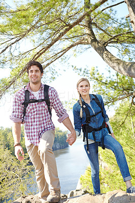 Buy stock photo Holding hands, view or happy couple hiking by river for travel, outdoor adventure or journey in nature. Mountain, woods or people in forest together on holiday vacation, lake or break to explore park