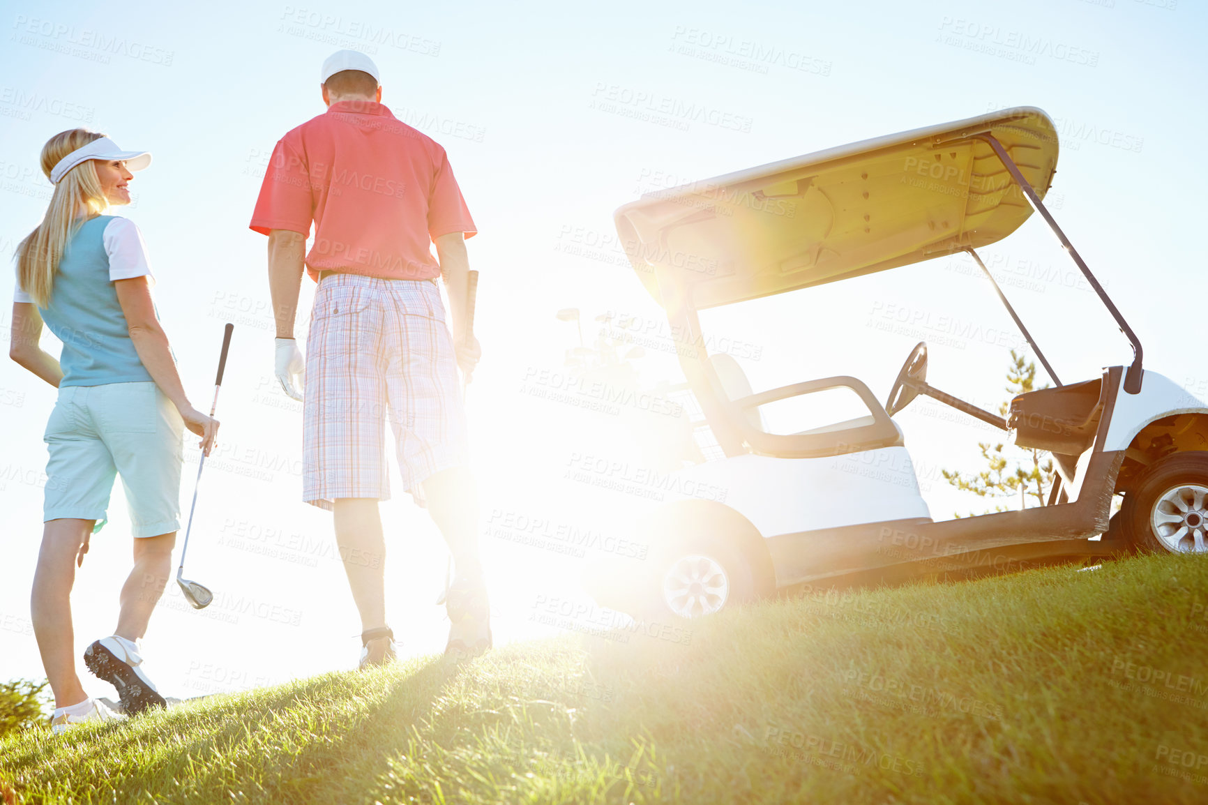 Buy stock photo Sports, golf course and back of couple for game, match and competition on field for activity. Morning, hobby and man and woman for playing, fun and practice together to relax, bonding and sun flare