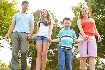 Buy stock photo Family, happy and holding hands in park for love, trust and excited for adventure in Australia. Parents, children and gesture in nature for guidance, support and safety on holiday or summer vacation