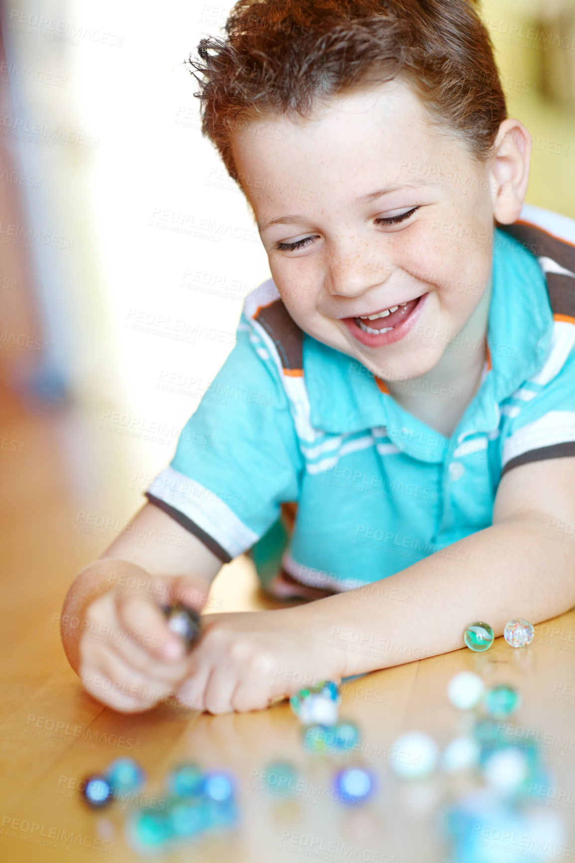 Buy stock photo Happy, child and boy play with marble on floor for funny game, relax and excited in home. Smile, kid and glass balls or toys on ground for creative collection, laugh or childhood development in house