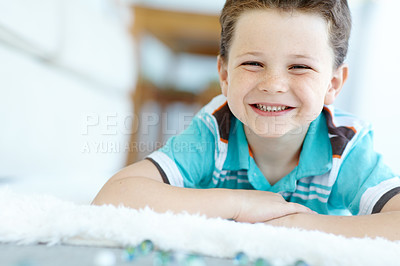 Buy stock photo Home, boy and smile with playing marbles on portrait for fun on school break on floor in Scotland. Male person, kid and happy at apartment with toys for games, child growth and brain development