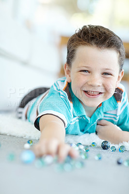 Buy stock photo Smile, portrait and child play with marbles on floor for funny game, relax or laugh in home. Face, happy boy and cute kid with glass balls or toys on carpet for creative collection or excited in USA