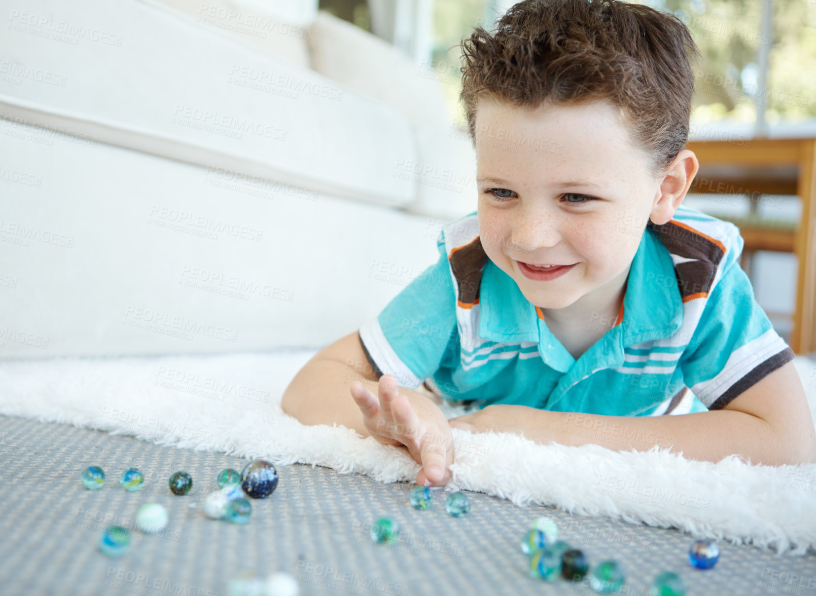 Buy stock photo Happy, kid and play with marble in home for funny game and relax in living room. Smile, child and boy with glass balls or toys on carpet for creative collection, laughing and development on floor