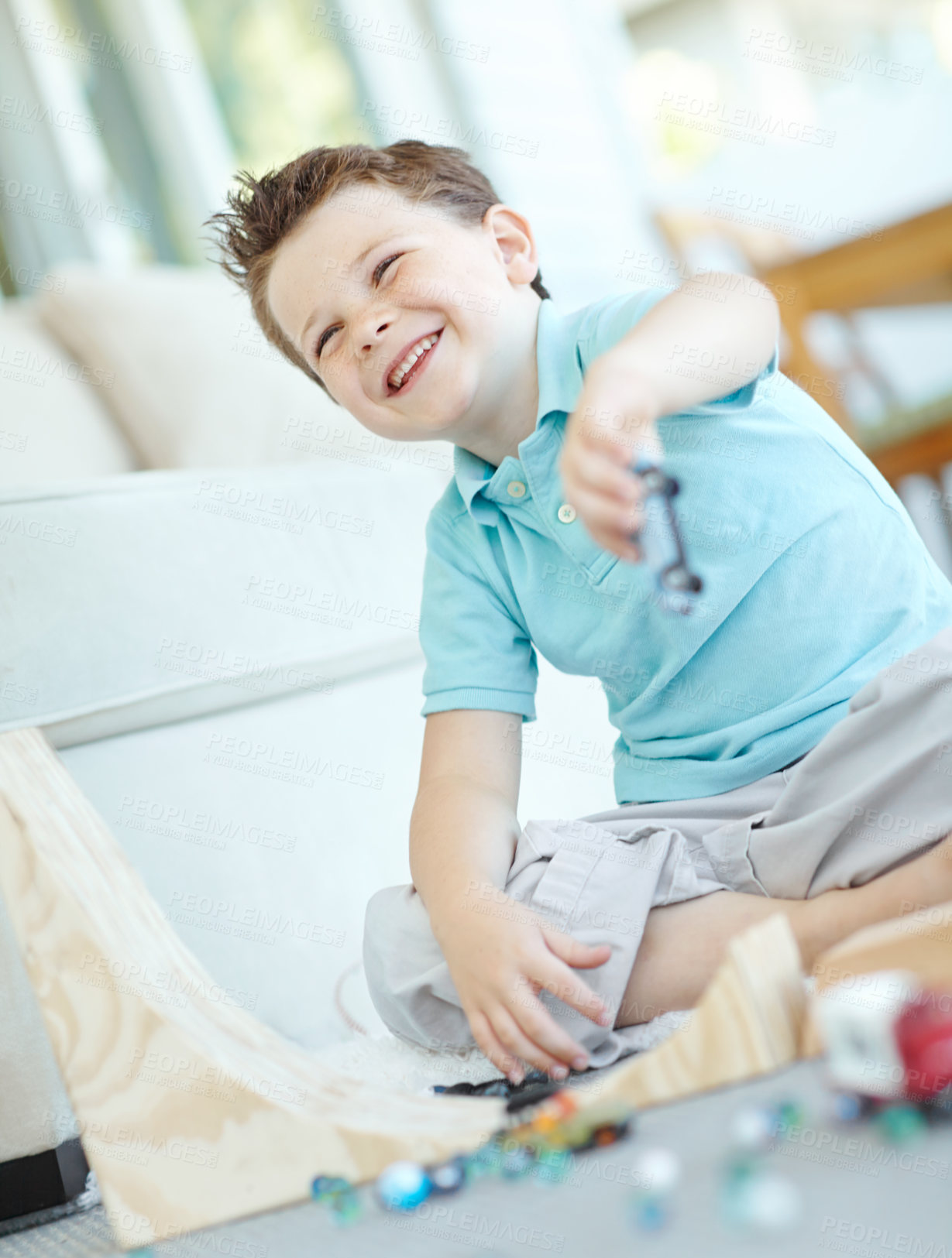 Buy stock photo Laughing, cars and kid in home playing for learning, development and fun with smile. Excited, marbles or boy enjoying games with plastic vehicle toys for childhood hobby or growth at house in England