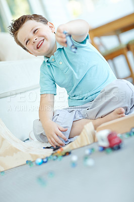 Buy stock photo Laughing, cars and boy in home playing for learning, development and fun with smile. Excited, marbles or kid enjoying games with plastic vehicle toys for childhood hobby or growth at house in England