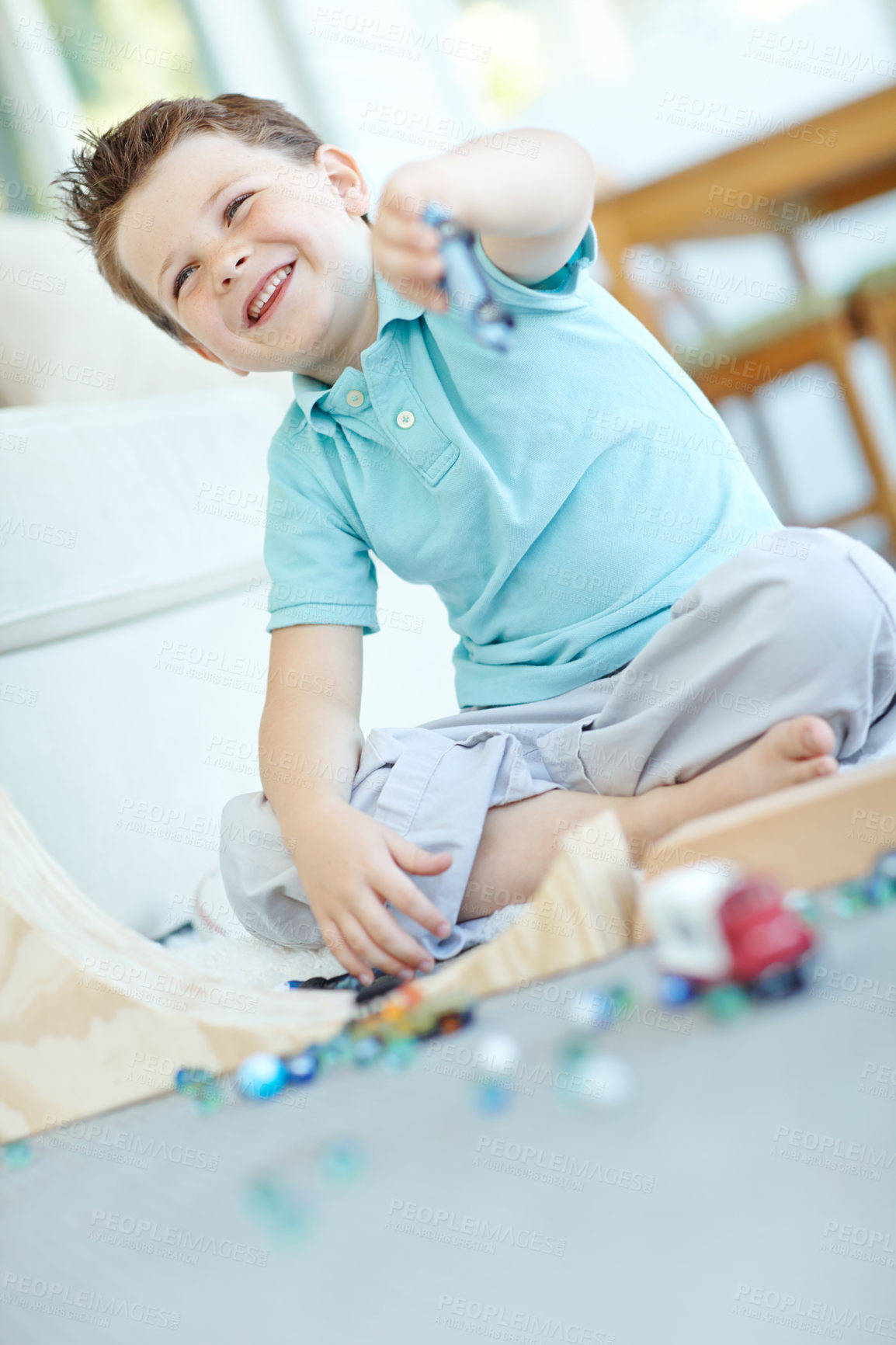 Buy stock photo Laughing, cars and boy in home playing for learning, development and fun with smile. Excited, marbles or kid enjoying games with plastic vehicle toys for childhood hobby or growth at house in England