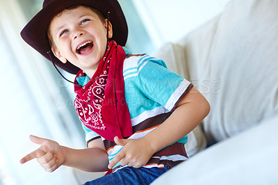 Buy stock photo Funny child, cowboy and game with gun gesture for fantasy, play or creative cosplay in home lounge. Kid boy, western costume and pistol fingers on sofa for shooting, laugh and excited for halloween