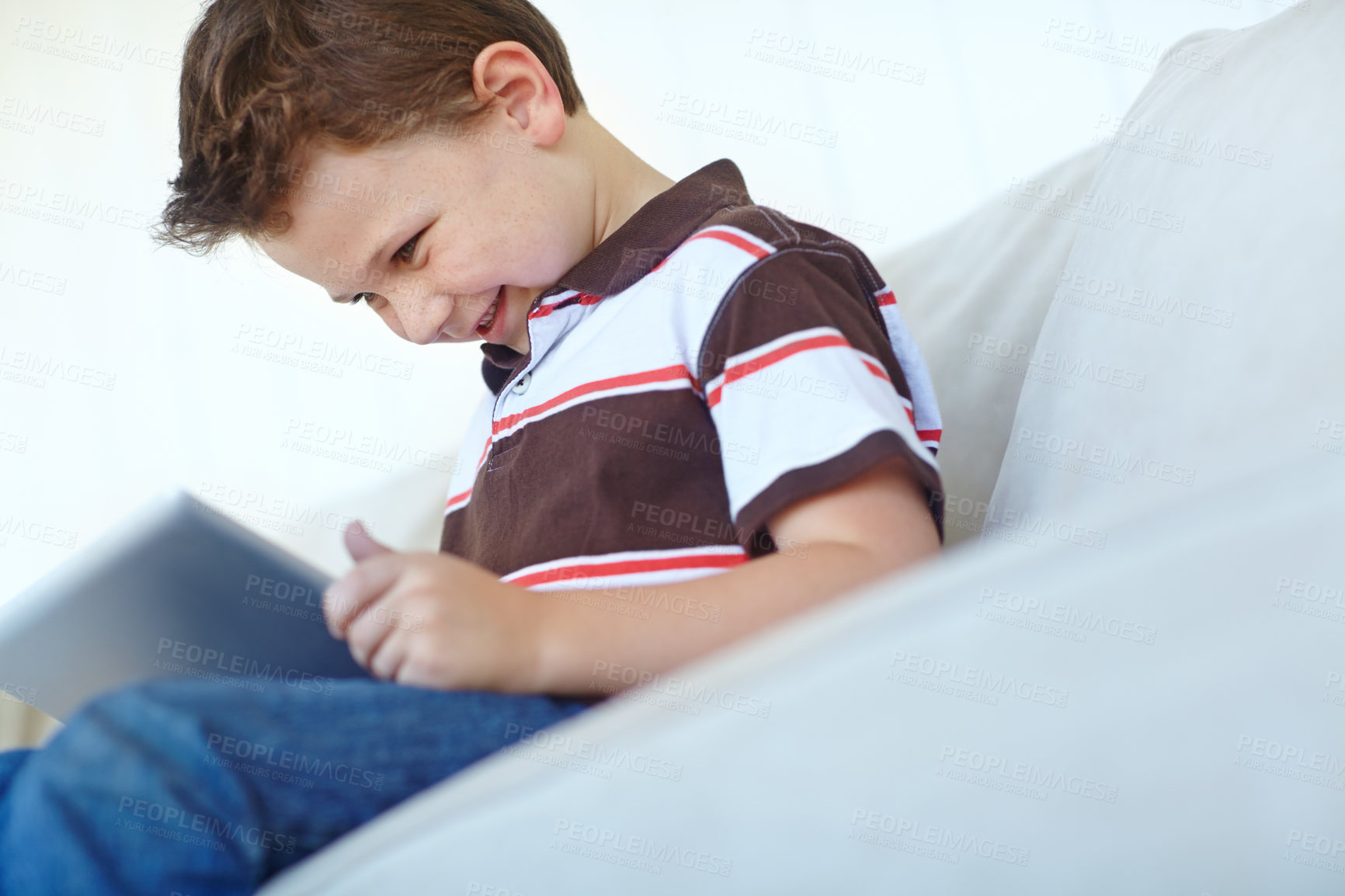 Buy stock photo Happy kid, tablet and relax on sofa in home, reading ebook and watch cartoon in low angle. Boy, child and digital technology for internet addiction, scroll app and play game for education in lounge