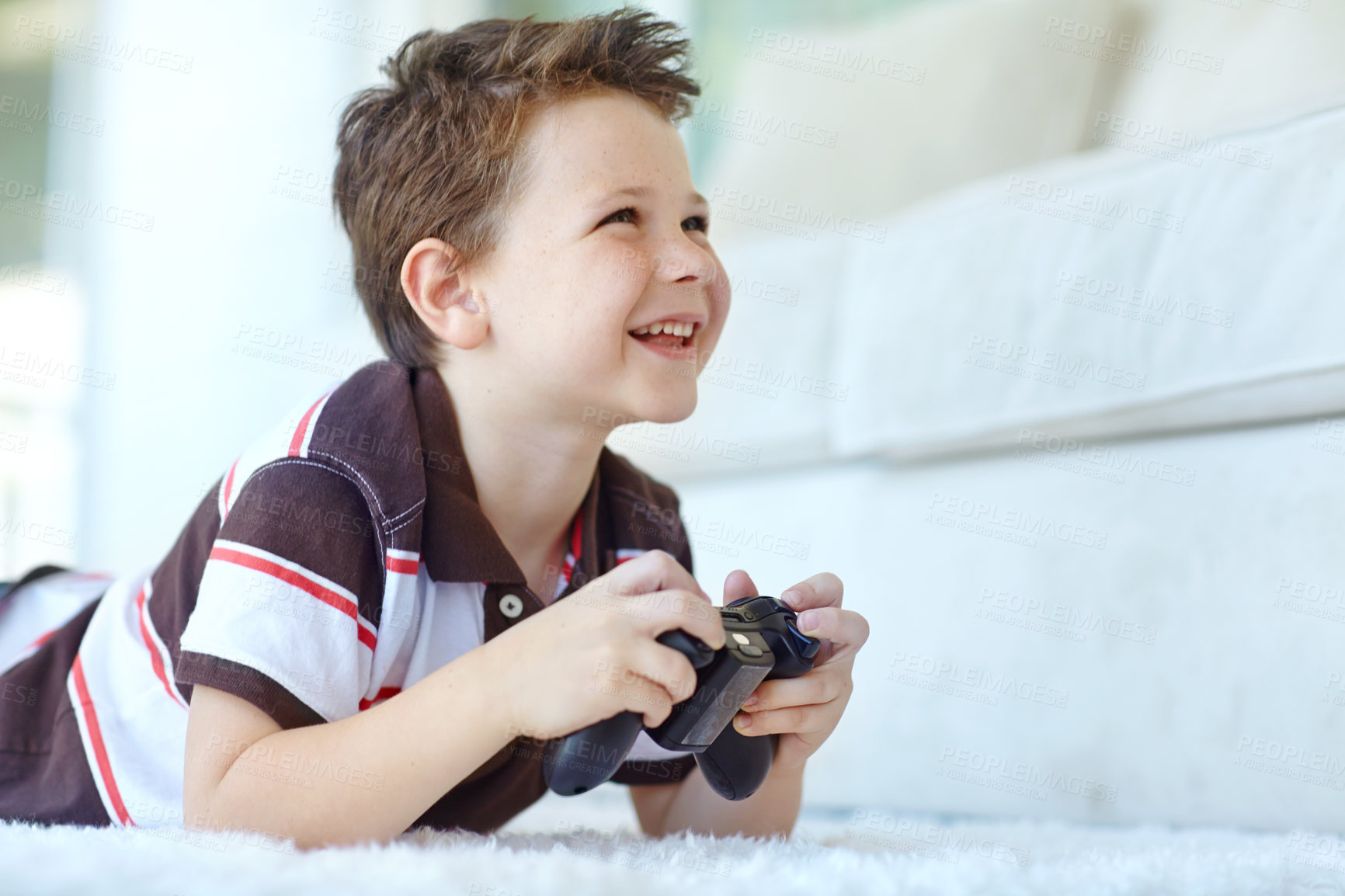 Buy stock photo Home, child and happy with controller for video game, playful and entertainment for childhood by carpet. Lounge, cheerful boy and gamer with equipment for navigation, character action and challenge