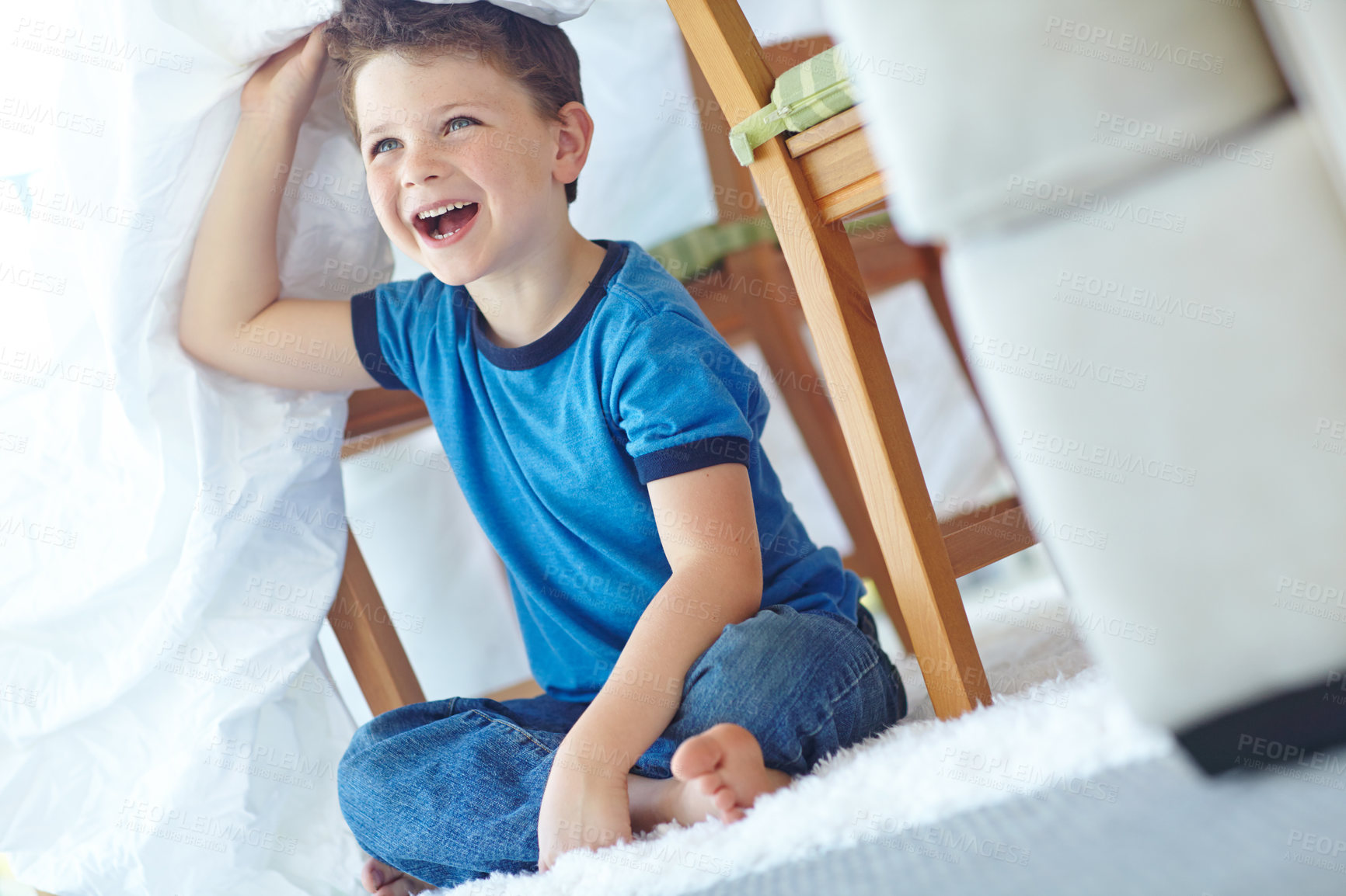 Buy stock photo Home, child and laughing with duvet for playing, entertainment and imaginative game for childhood by carpet. House, young boy and underneath with smile for fantasy, hide and seek in family apartment