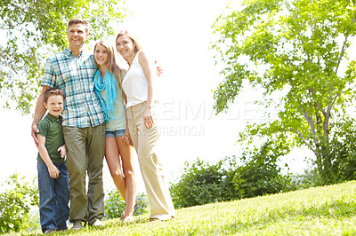 Buy stock photo A happy family standing together in the park on a summer's day