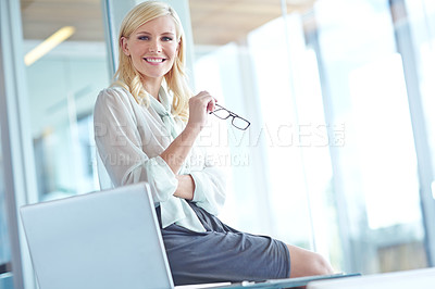 Buy stock photo Portrait of a smiling business woman sitting on her desk with her laptop in front of her with copyspace