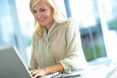 Buy stock photo A smiling corporate woman working on her laptop