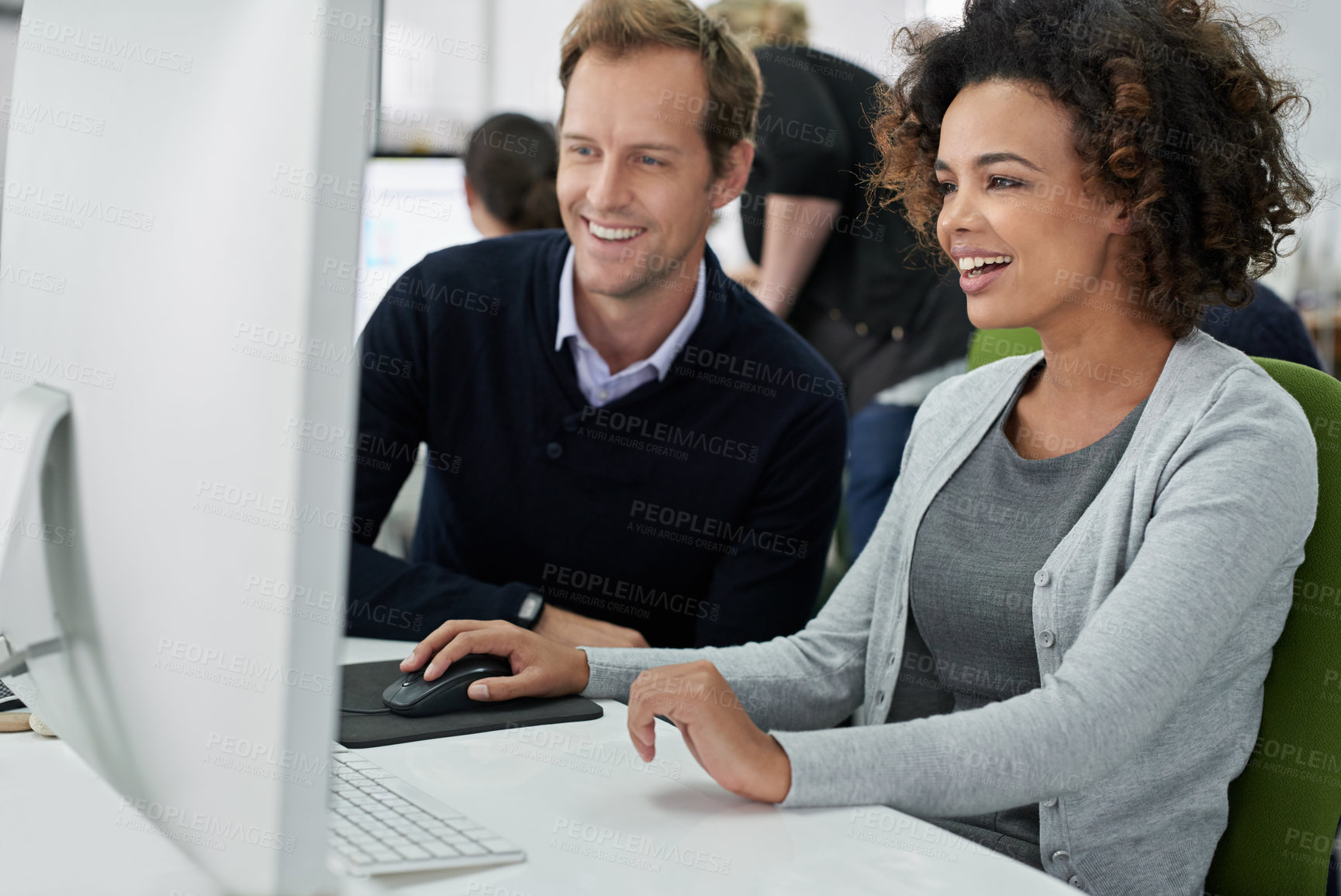 Buy stock photo Male and female coworkers working positively on a project together