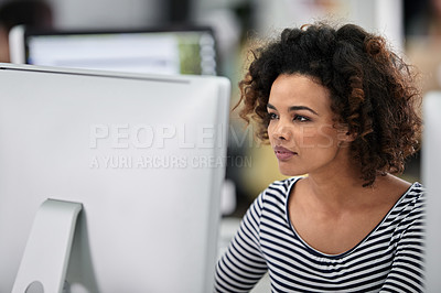 Buy stock photo Serious businesswoman working at her desk, looking thoughtfully at his computer