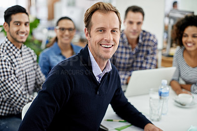 Buy stock photo Businessman smiling towards the camera with his smiling colleagues in the background