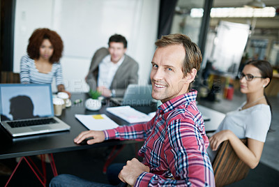 Buy stock photo Portrait of an office worker sitting at a boardroom table with colleagues in the background