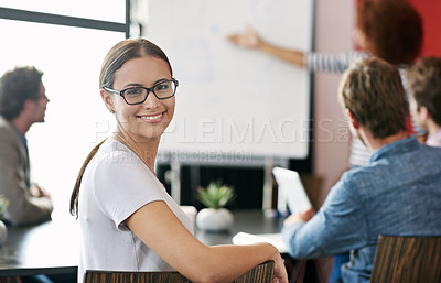 Buy stock photo Portrait of a young office worker in a meeting with colleagues in the background
