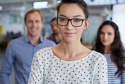 Buy stock photo Portrait of a serious young woman with colleagues in the background