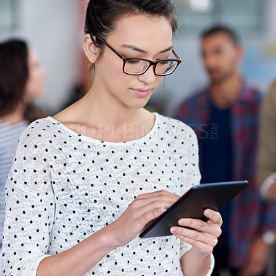 Buy stock photo Cropped closeup of a young woman working on her digital tablet in the office