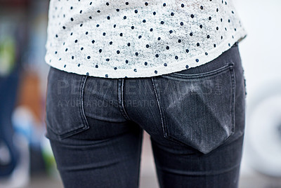 Buy stock photo Cropped shot of a young woman's butt, with the outline of her cell phone visible in the pocket of her denim jeans