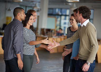 Buy stock photo Creative professionals greeting each other in an open office space