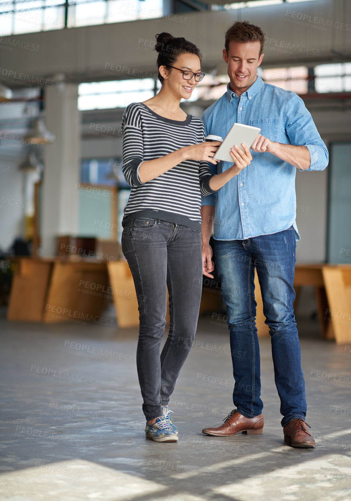 Buy stock photo Male and female colleagues looking at something on a digital tablet together