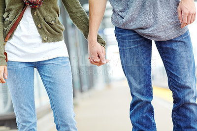 Buy stock photo Cropped image of a couple holding hands at a train station 