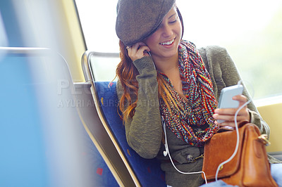 Buy stock photo Woman, phone and earphones on train for travel, music and streaming with app, social media and web. Art teacher, mobile and smile on subway with ebook, commute and podcast inspiration for creativity