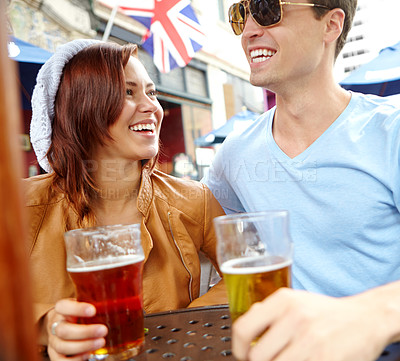 Buy stock photo Date, couple and pub with beer, smile and travel for romance and London adventure together. Man, woman and alcohol with conversation, love and bonding with drink at bar for anniversary or honeymoon