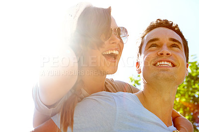 Buy stock photo Close up of a laughing girlfriend getting a piggyback from her boyfriend