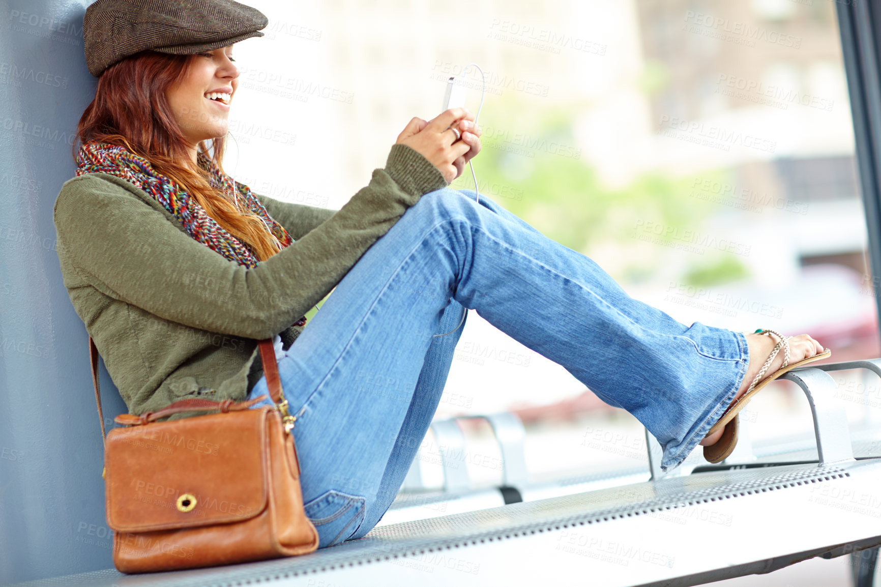 Buy stock photo Train station, woman and smile on smartphone with earphones for streaming music and audio. Female person, outside and happy with texting on internet, social media and message for communication