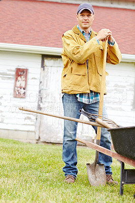 Buy stock photo Outdoor, farmer and man in portrait with wheelbarrow, gardening and agriculture with confidence on farm. Countryside, male person and owner with equipment for transport, cleaning and spade as tools