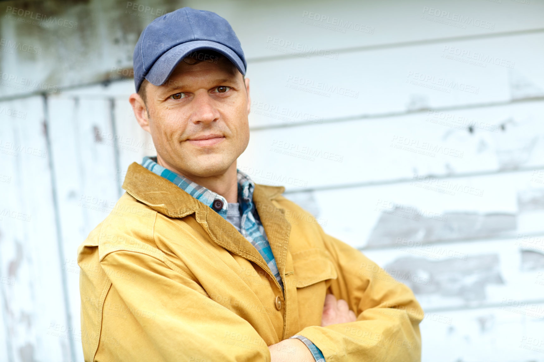 Buy stock photo Man, agriculture and outdoor with arms crossed in portrait by barn, cap and confident for job in countryside. Person, farmer and happy with pride by shed for sustainable small business in New Zealand