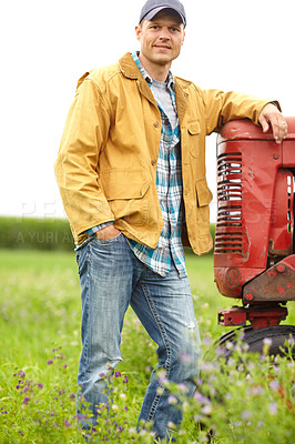 Buy stock photo Portrait of a man standing in a field with his arm resting on the hood of a tractor