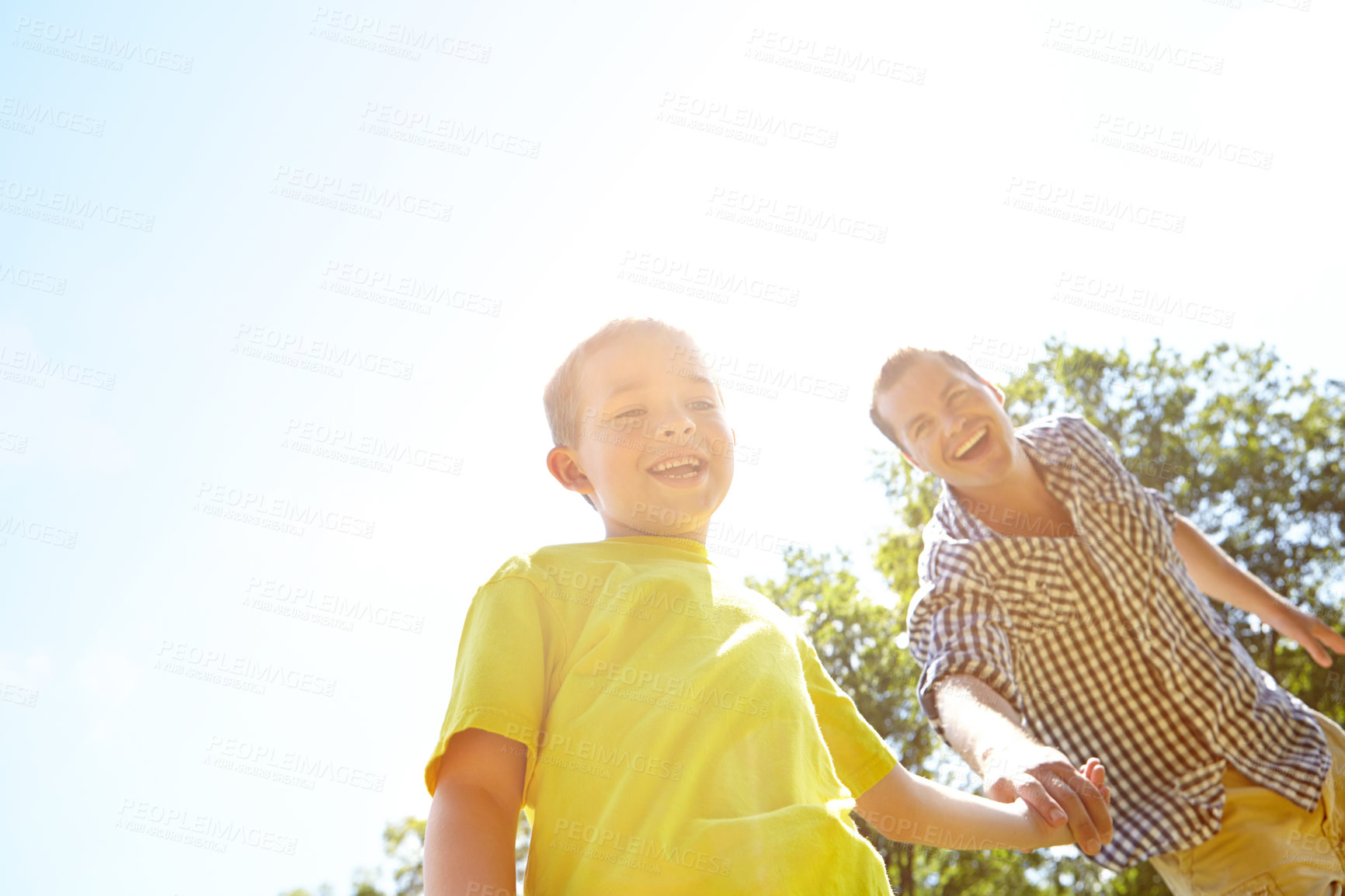 Buy stock photo Outdoor, dad and smile on holding hands with boy for bonding, fun or support in England. Low angle, parent and happy with kid at park for love, trust or care as family for child development or growth