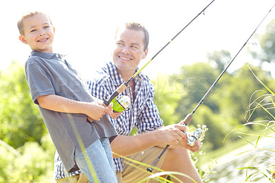 Buy stock photo Cute young boy standing beside his father while holding a fishing rod and smiling
