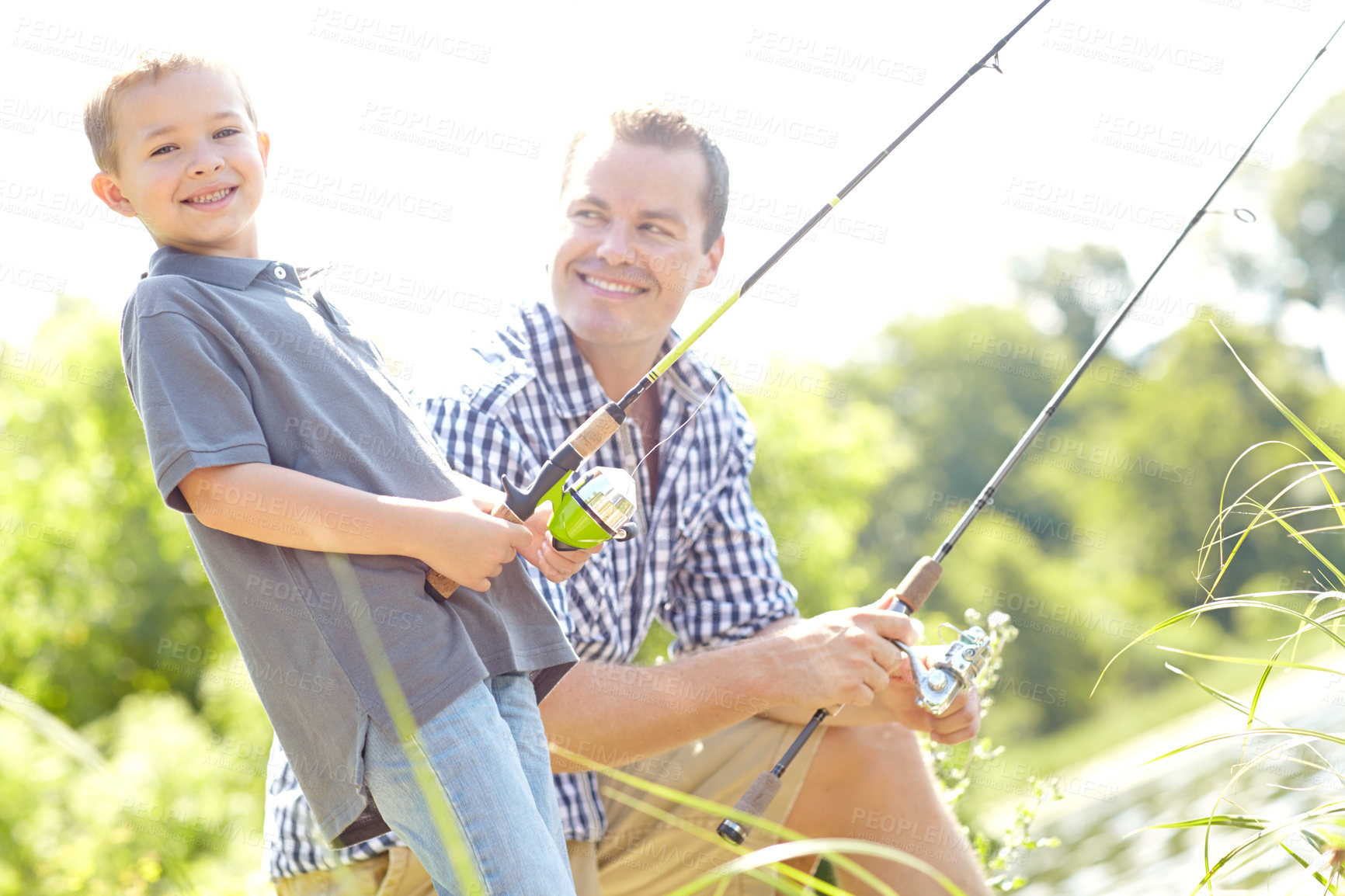 Buy stock photo Father, son and happy for fishing at lake with help for support, bonding or care in England. People, parent and smile with kid at river with teaching, learning or skill as family tradition for growth