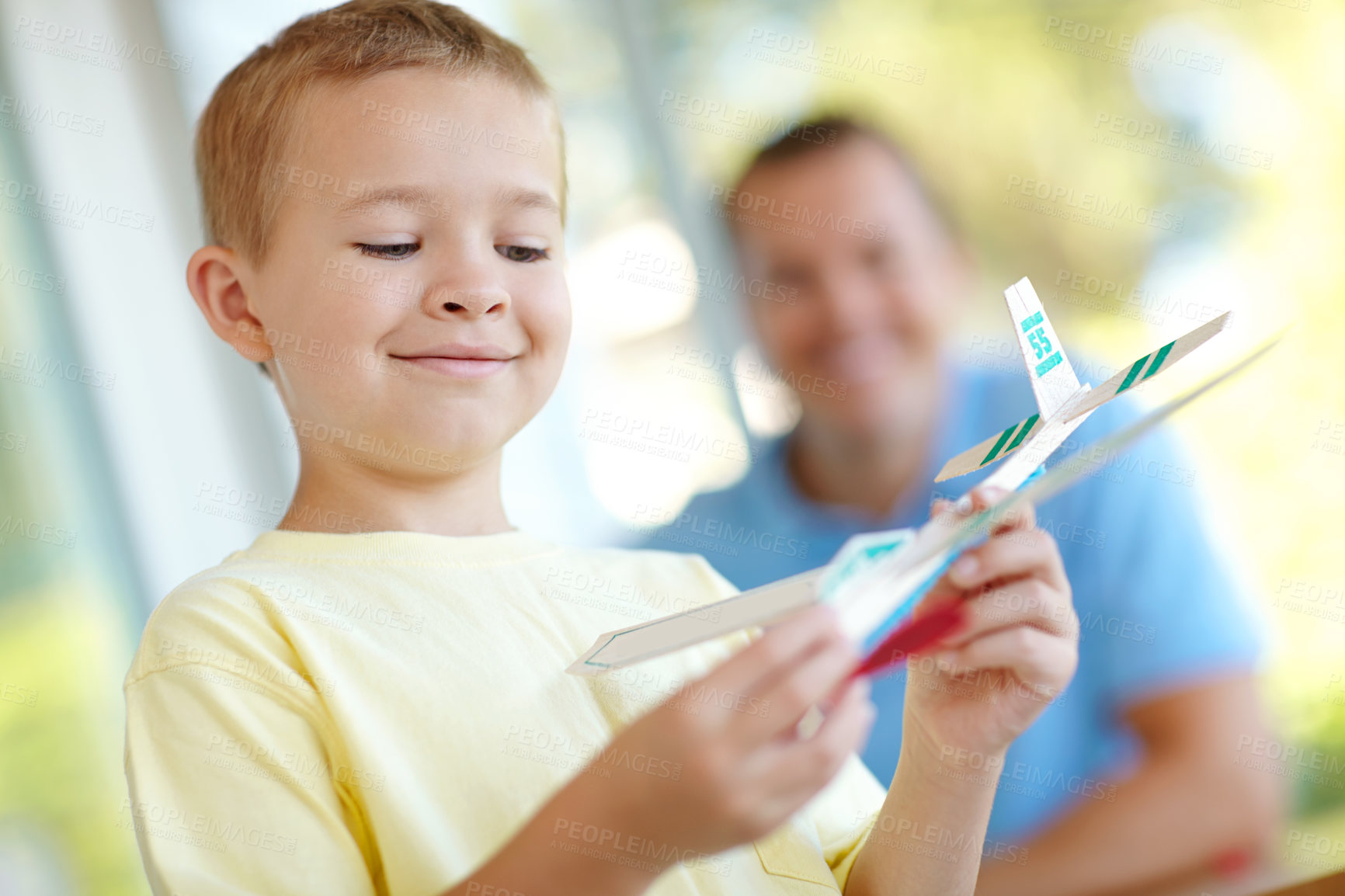 Buy stock photo Toys, plane and playful boy with dad, smile and fun on patio together for morning adventure. Playing, weekend games and happy child relax on porch with paper airplane, father and son bonding in home