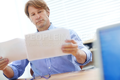 Buy stock photo Mature male business associate looking over documents