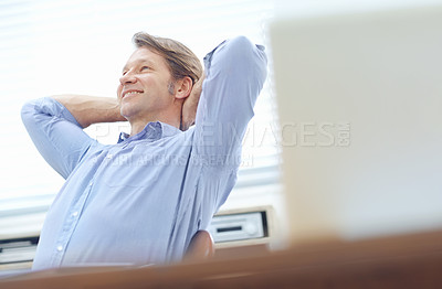 Buy stock photo Relaxed, attractive businessman sitting back in an office chair with his hands behind his head