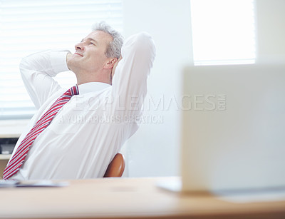 Buy stock photo Relaxed businessman leaning back in an office chair with his hands behind his head