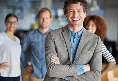 Buy stock photo Portrait  of a smiling mature man with friendly coworkers behind him