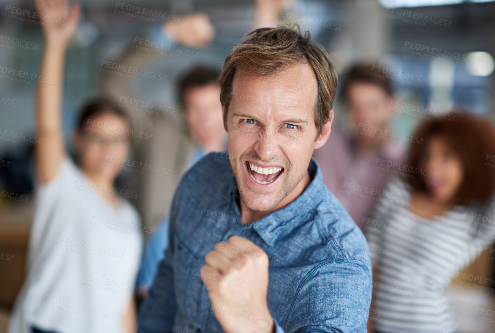 Buy stock photo Mature man shouting triumphantly and making  a fist with celebrating staff in the background